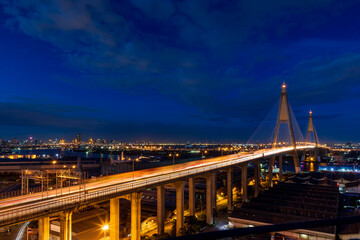 Fototapeta na wymiar Large suspension bridge over Chao Phraya river with traffic at twilight