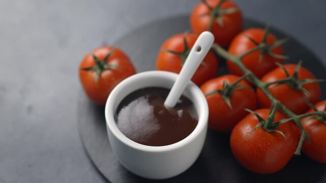 Farm tomatoes and tomato sauce. The camera moves forward, the subject becomes clear. Dark background