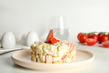 Delicious salad with fresh crab sticks on white table