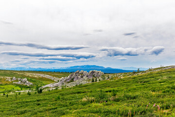 Fototapeta na wymiar green meadow with a ridge of gray rocks