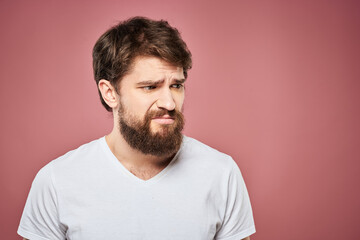 emotional man white t shirt sad facial expression pink background