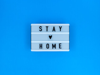 Light box with Stay home quote on a blue background.