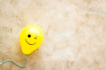 Happiness emotion face on balloon - joy mood background. Top view, copy space