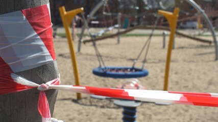 Caution Tape on Empty Playground Closed due to Coronavirus Epidemic Quarantine