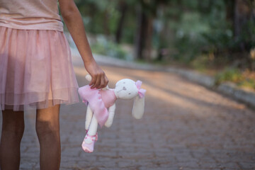 Sad girl hugging teddy bear sadness alone in green garden park. Lonely girl feeling sad unhappy walking outdoors with best friend toy. Autism child play teddy bear best friend. Family violence concept