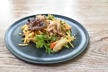 spicy fried pork with slice ginger and mushroom on plate