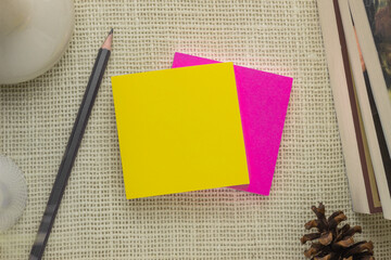 yellow and pink sticky notes paper on table top view with pencil and books copy space for writing message