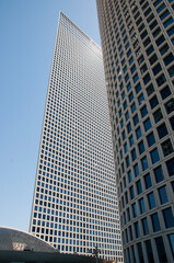 Obraz premium Modern high-rise building made of glass against the blue sky. Sunny day.