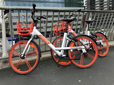 Rotterdam, the Netherlands - October 23, 2018: Two Mobike's parked next to a fence in the Dutch city of Rotterdam.  Mobike is a bicycle sharing system.