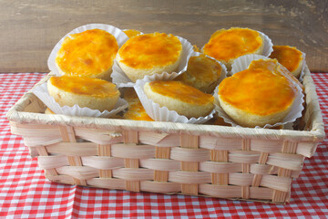 pile of empadas or empadinhas is a very popular and traditional snack of Brazilian cuisine, in a rustic basket on a table lined with a towel
