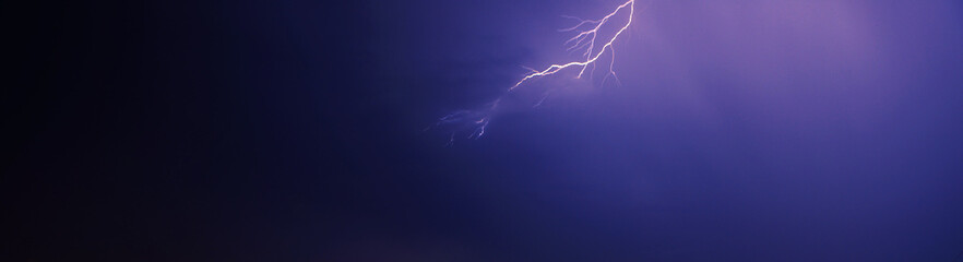 bright yellow lightning on blue dark sky