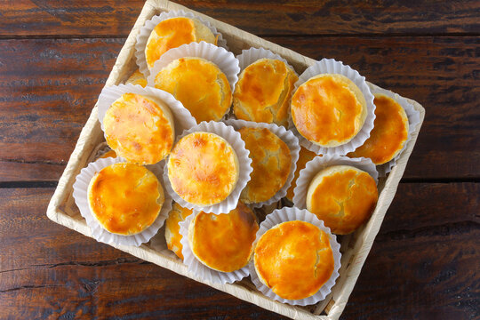 pile of empadas or empadinhas is a very popular and traditional snack of Brazilian cuisine, in a rustic basket on a table lined with a towel