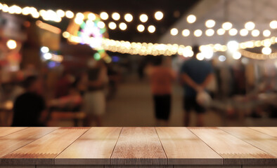 Empty wood table on blur night market background
