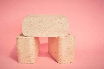 fuel briquettes on a pink background, natural fuel for home heating
