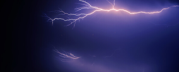 bright yellow lightning on blue dark sky