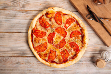 Margherita pizza with tomatoes on the wooden table
