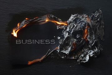 Burning piece of black paper with the word 