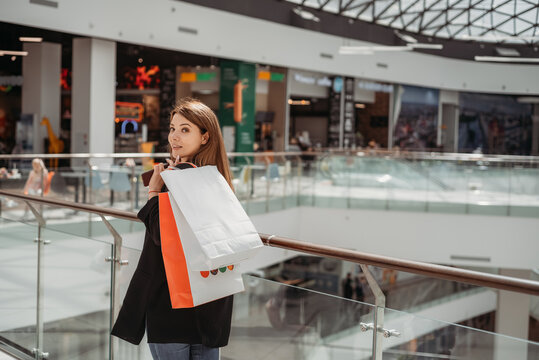 Beatiful dark-haired girl with a shopping bag at the mall