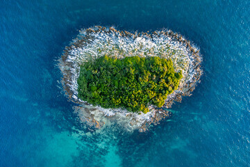 Heart shaped island on the Adriatic sea seen from birds eye perspective.