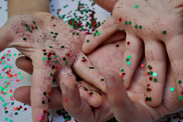 Obraz na płótnie Canvas Colorful glitter on kids hands