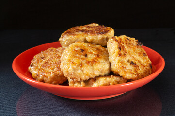 Roasted chop in red plate on black background
