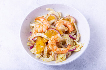 Shrimp salad with fennel, orange and red onion. Close-up, selective focus.