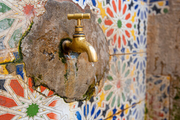 Copper faucet with drinking water on a street in medina, Morocco
