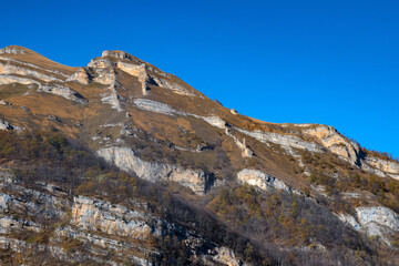 Rocks and dry grass in North Caucasus mountains in autumn on sunny day