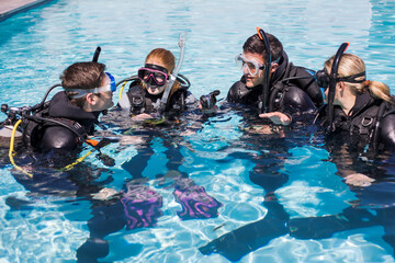 Scuba dive training in a pool with a group of students interacting.