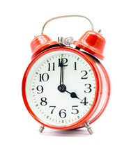 Roter Wecker zeigt vier Uhr vor weißem Hintergrund