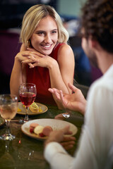 A young couple in love chatting at Valentine's day celebration at a restaurant. Together, Valentine's day, celebration