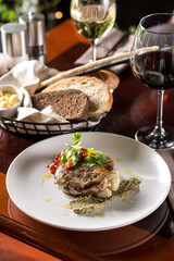 Beef rissole juicy beef steak with tomato sauce and glass of red wine on wooden table at restaurant