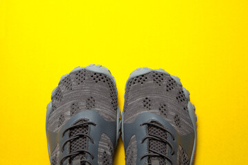 Sport gray sneakers isolated on yellow background