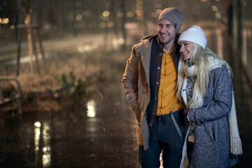 A young couple in romantic moments on a magical night on a snowy weather in the city. Love, together, walk, snow, city