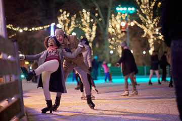 A young girl falling down at ice rink. Skating, closeness, love, together