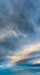 Fototapeta premium Fantastic clouds at sunrise, vertical panorama
