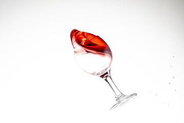 splash of red wine in glass on white background close up