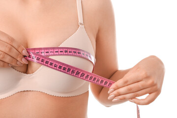 Young woman measuring her breast on white background