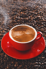 Cup of hot coffee on roasted beans