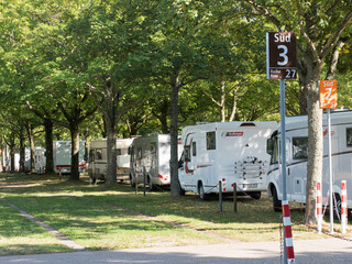 A row of motorhomes are closely parked one after the other at the Motorhome Show in Dusseldorf.Signs indicate which row vehicles are in