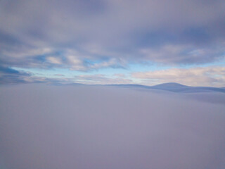 High aerial flight between fog and clouds.