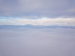 Fototapeta na wymiar High aerial flight between fog and clouds.