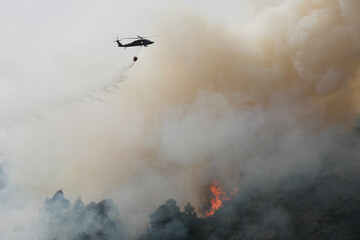 helicopter putting out fire in mountains