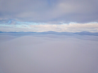 Fototapeta na wymiar High aerial flight between fog and clouds.