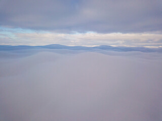High aerial flight between fog and clouds.