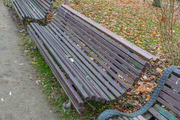A recreation bench made of wood in a city park in autumn