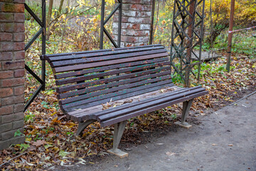 A recreation bench made of wood in a city park in autumn