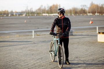 cyclist in black clothes and helmet trains on a bicycle