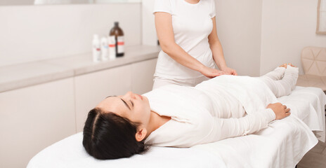 Asian woman during anti-cellulite bandage wrap procedure. Wet whiskey swaddling to remove cellulite on female body