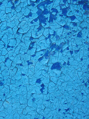 old blue paint on a wooden wall texture. Aged painted cracked boards with blue color peeling paint. Old natural grunge textured wooden texture. Weathered wood.